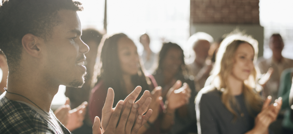 young-man-in-a-group-clapping-at-a-diversity-event