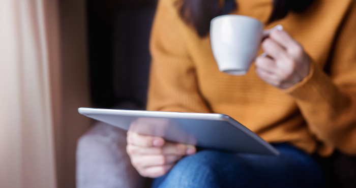 sqe-student-reading-on-tablet-seated-drinking-from-cup