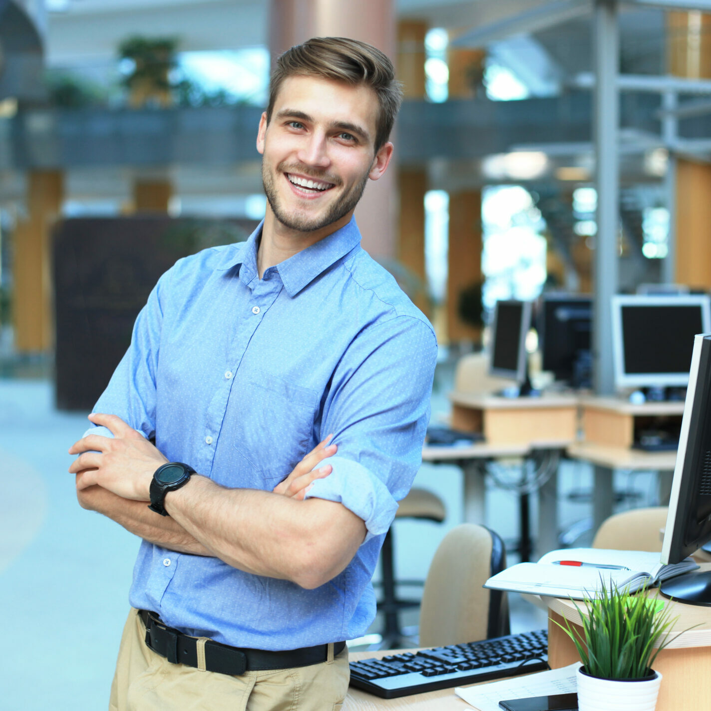 Young man posing confident and positive in professional workplace office with space. Young man posing confident and positive in professional workplace office with space