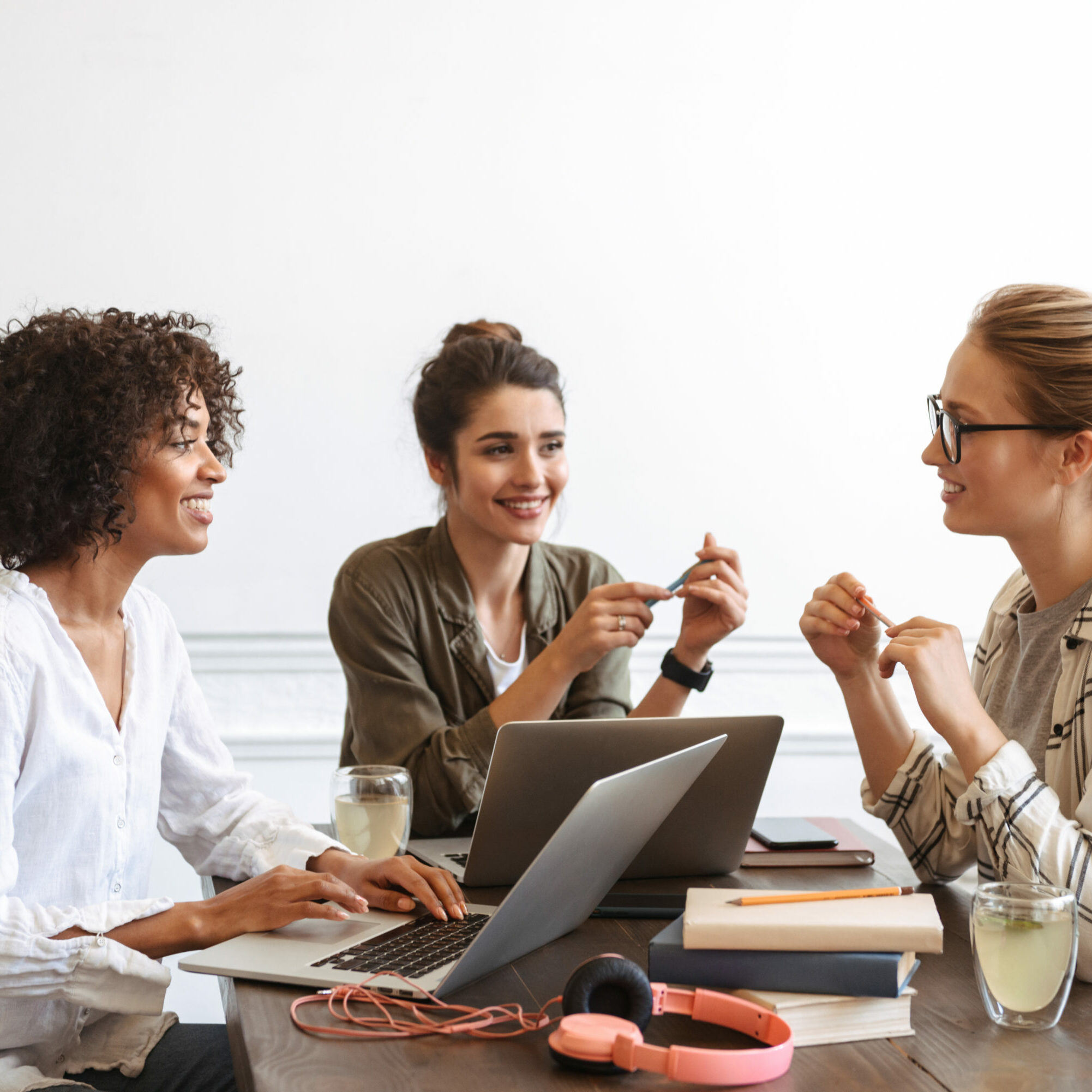 Group of cheerful young women studying together Group of multiethnic cheerful young women studying together at the coffee shop